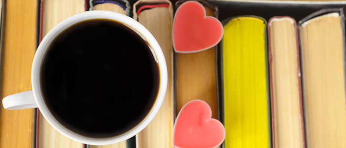 A cup of black coffee and two heart cookies